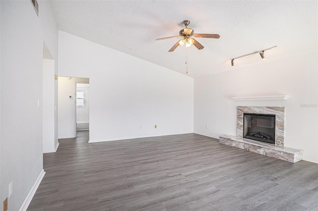 1902 Cedarbrooke Dr, Lutz, FL 33549 - unfurnished living room featuring a ceiling fan, rail lighting, a textured ceiling, wood finished floors, and a fireplace