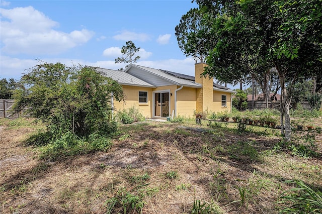 1902 Cedarbrooke Dr, Lutz, FL 33549 - rear view of house featuring a chimney and a metal roof