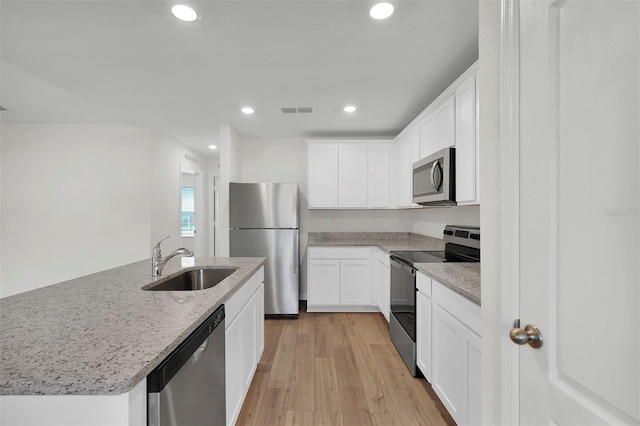 7504 SW 128th St, Ocala, FL 34473 - kitchen with stainless steel appliances, white cabinets, recessed lighting, light stone countertops, and light wood-style flooring