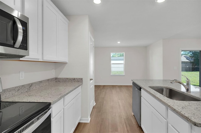 7504 SW 128th St, Ocala, FL 34473 - kitchen featuring stainless steel appliances, recessed lighting, white cabinets, light wood-style flooring, and light stone countertops
