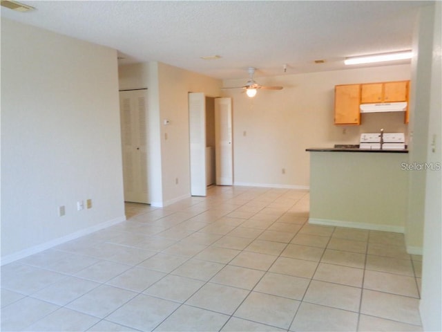 unfurnished living room featuring light tile floors and ceiling fan