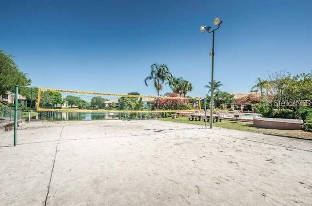 view of home's community with a water view and volleyball court