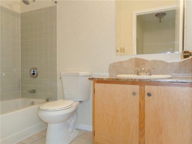 full bathroom with tile floors, tiled shower / bath combo, toilet, and vanity