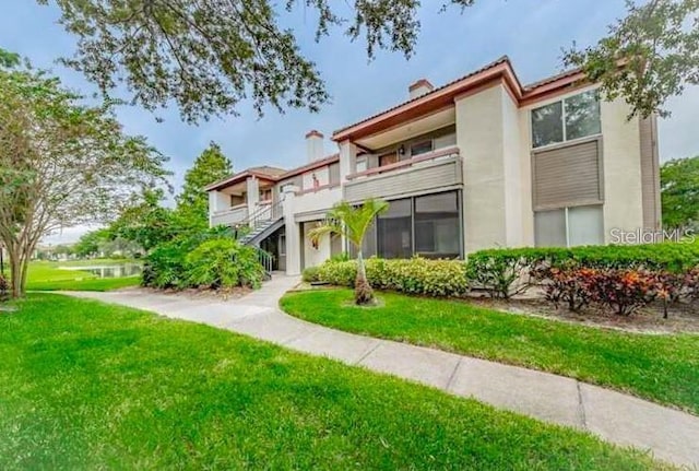 view of front of property with a front lawn and a balcony