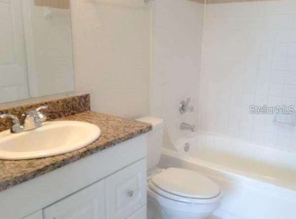 full bathroom featuring vanity, shower / bathing tub combination, and toilet