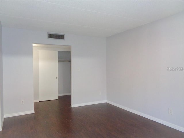 spare room featuring dark wood-type flooring