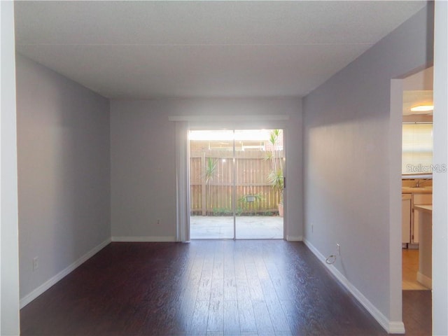 unfurnished room featuring dark wood-type flooring