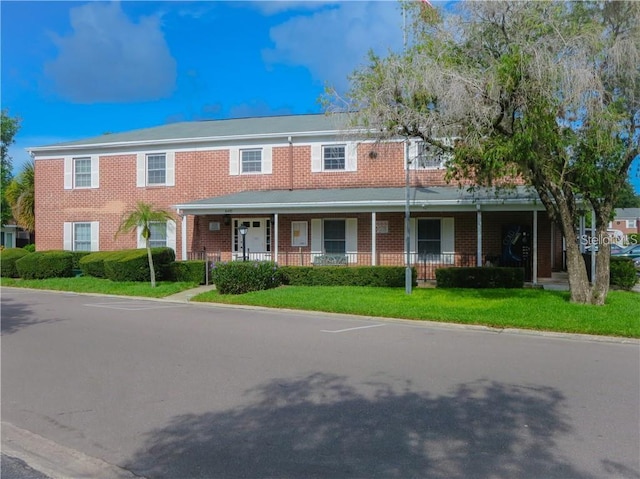 view of front of property with a front yard and covered porch