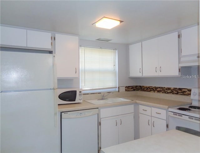 kitchen with white cabinetry, sink, exhaust hood, and white appliances