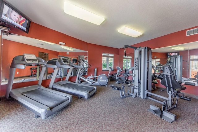 workout area with carpet and a textured ceiling