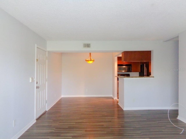 empty room with a textured ceiling and dark wood-type flooring