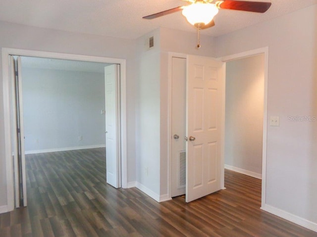 unfurnished bedroom featuring a closet, ceiling fan, and dark wood-type flooring