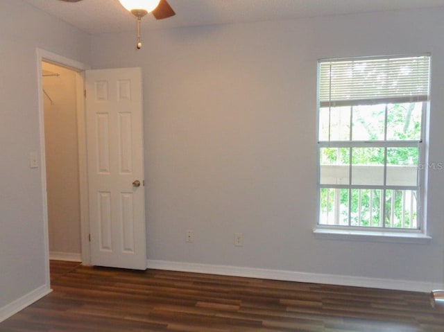 spare room with dark hardwood / wood-style floors and ceiling fan