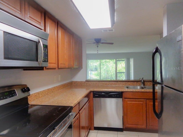 kitchen with light tile floors, stainless steel appliances, ceiling fan, and sink