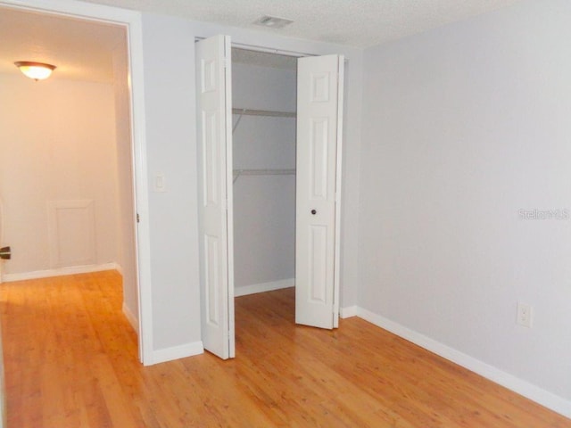 unfurnished bedroom with a closet and light wood-type flooring