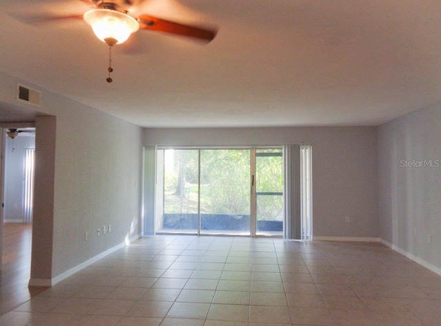 empty room with ceiling fan and light tile floors