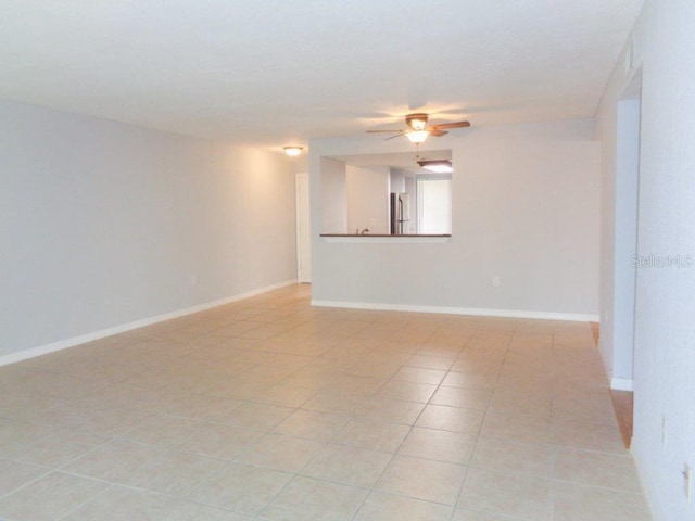 unfurnished room with ceiling fan and light tile floors