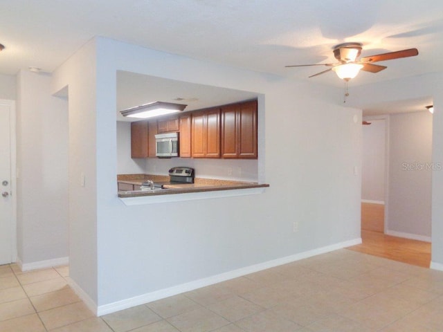 kitchen with range, ceiling fan, and light tile floors