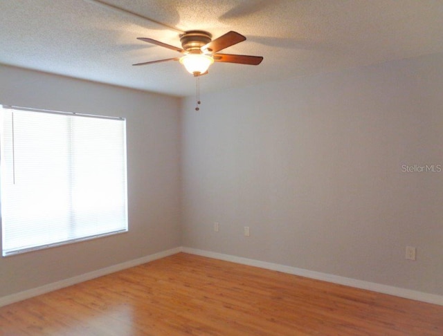 empty room with light hardwood / wood-style floors, a textured ceiling, and ceiling fan