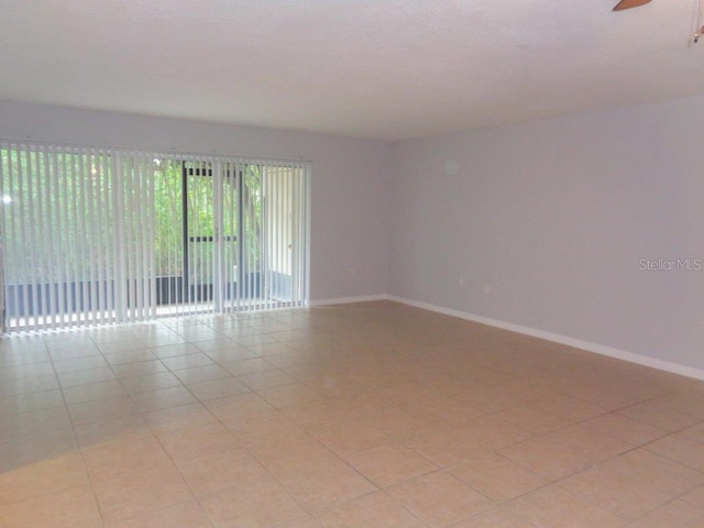 tiled empty room featuring ceiling fan