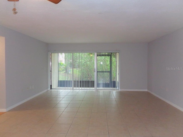 unfurnished room with ceiling fan, a healthy amount of sunlight, and light tile flooring