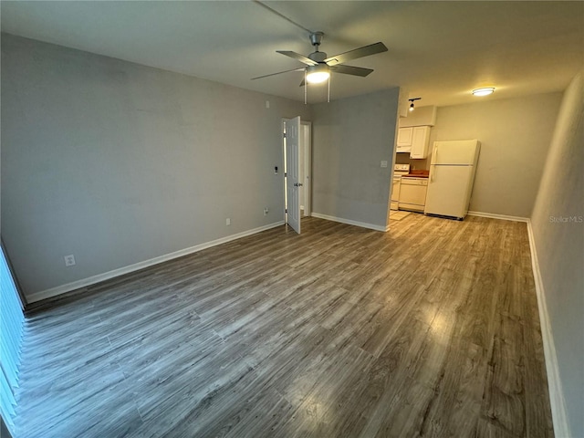 unfurnished bedroom with hardwood / wood-style floors, ceiling fan, and white fridge