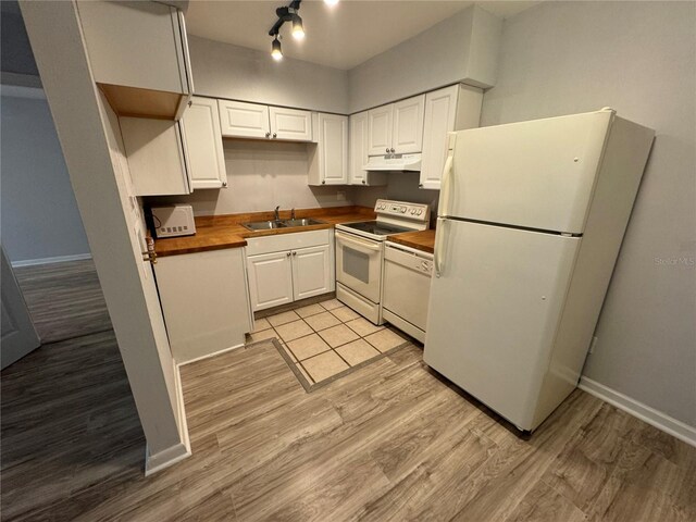 kitchen featuring white cabinets, white appliances, light wood-type flooring, and sink