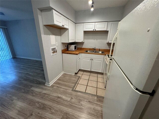 kitchen featuring light hardwood / wood-style floors, sink, white appliances, and white cabinetry