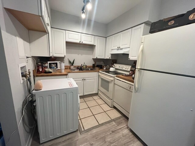 kitchen with white cabinets, white appliances, washer / clothes dryer, and light wood-type flooring