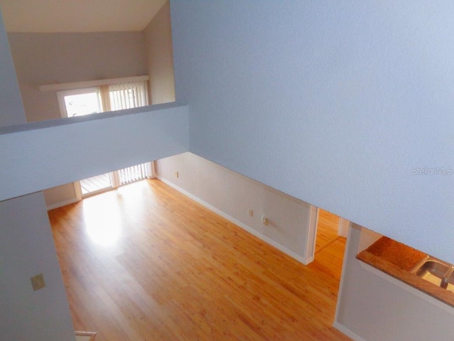 spare room with vaulted ceiling and hardwood / wood-style flooring