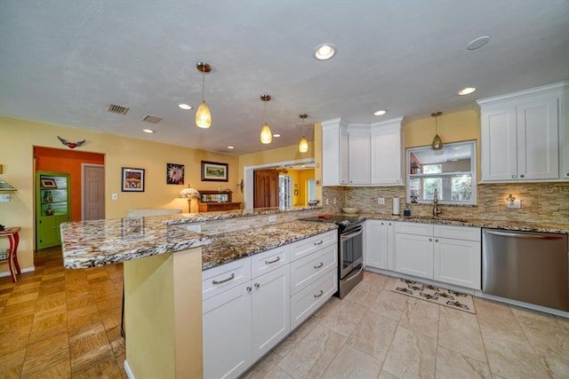 kitchen featuring stainless steel appliances, decorative light fixtures, kitchen peninsula, white cabinets, and sink