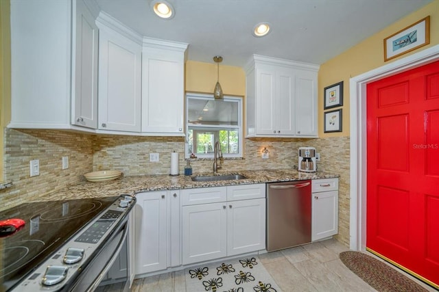 kitchen featuring sink, light stone counters, stainless steel appliances, tasteful backsplash, and white cabinetry