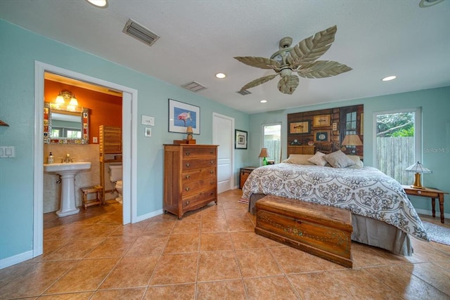 bedroom featuring ensuite bath, light tile flooring, ceiling fan, and sink