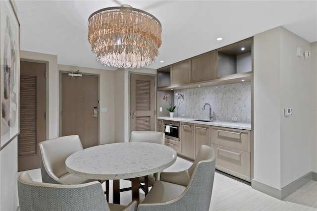 dining space with sink and an inviting chandelier