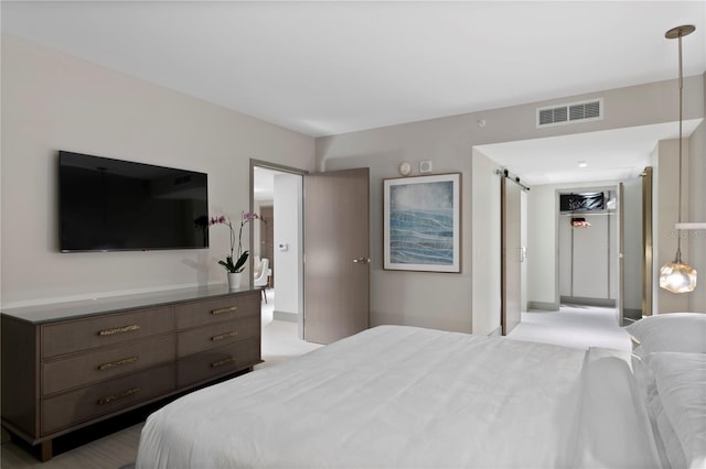 bedroom featuring a barn door and light colored carpet