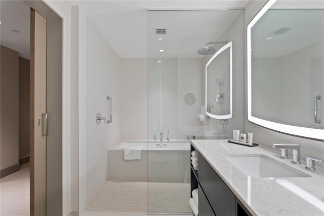 bathroom featuring a shower with door and vanity with extensive cabinet space