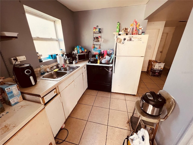 kitchen with white appliances, light tile patterned floors, sink, and white cabinets