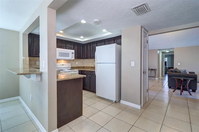 kitchen featuring light tile floors, tasteful backsplash, white appliances, dark brown cabinets, and light stone counters