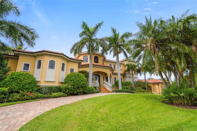 mediterranean / spanish home with a front lawn