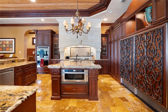 kitchen with light stone countertops, ornamental molding, stainless steel appliances, a raised ceiling, and pendant lighting