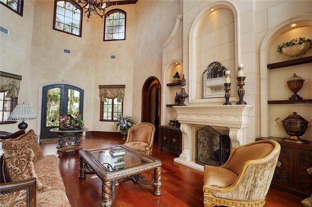 sitting room with french doors, a towering ceiling, and hardwood / wood-style flooring