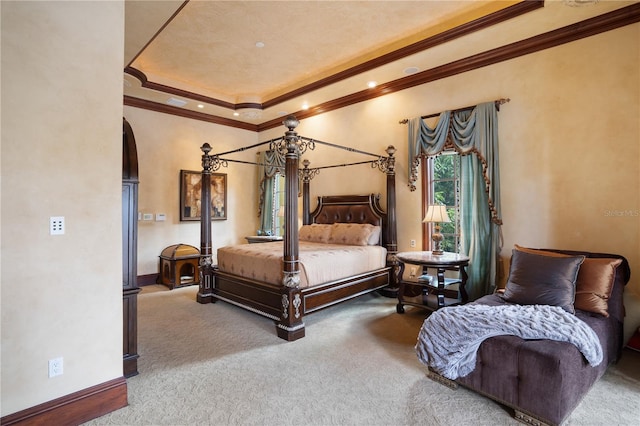 carpeted bedroom featuring ornamental molding and a tray ceiling