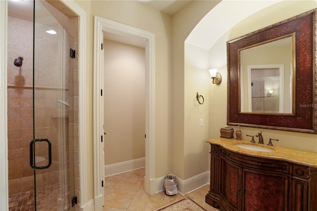 bathroom featuring tile patterned floors, vanity, and a shower with shower door