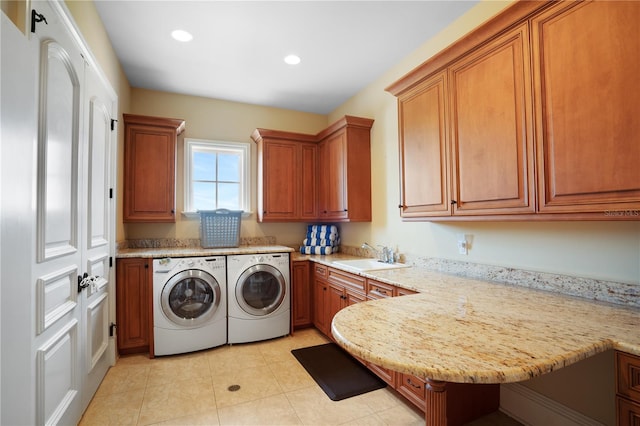 laundry room featuring cabinets, light tile patterned floors, washer and clothes dryer, and sink