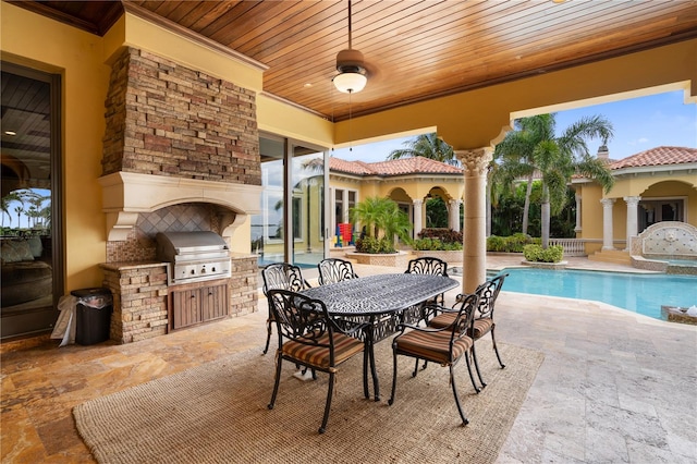 view of patio featuring a grill, area for grilling, and an outdoor stone fireplace