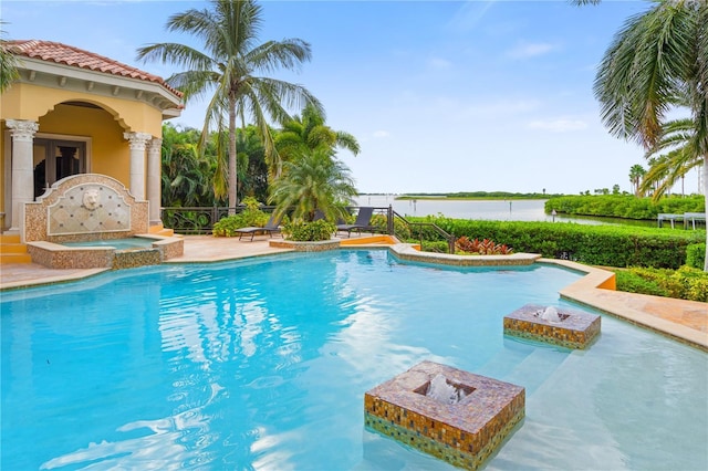 view of swimming pool with a water view and an in ground hot tub