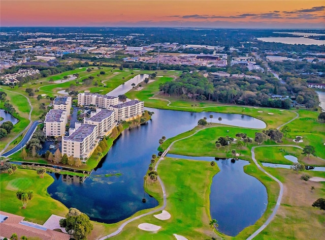 aerial view at dusk featuring a water view