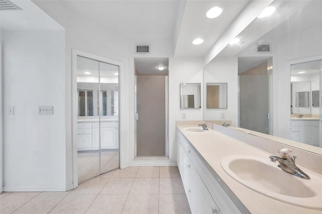 bathroom with vanity with extensive cabinet space, tile floors, and double sink