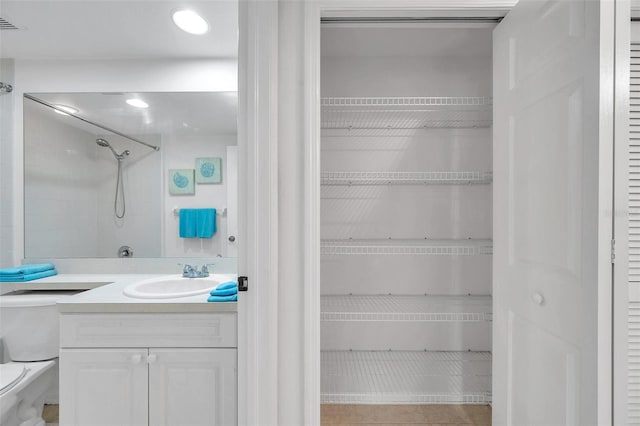 full bathroom featuring toilet, tile floors, tiled shower / bath combo, and vanity