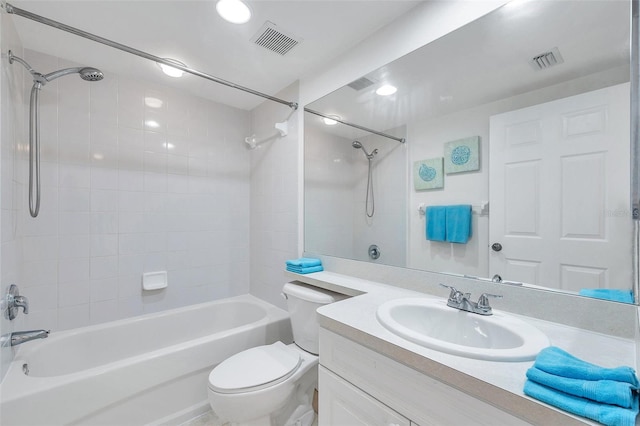 full bathroom featuring tiled shower / bath combo, large vanity, and toilet